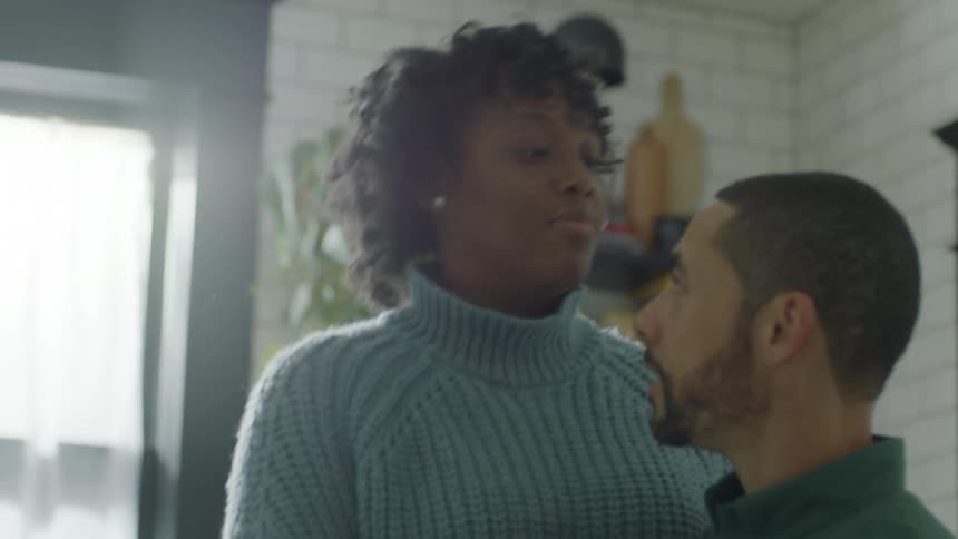 A wife kissing her husband on the head