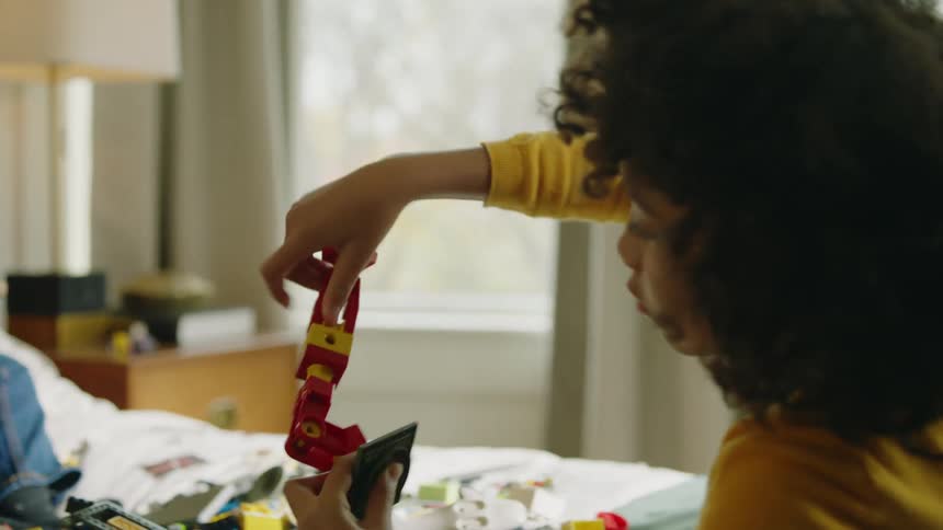 Parents waiting for their children to stop playing with toys in bed at home