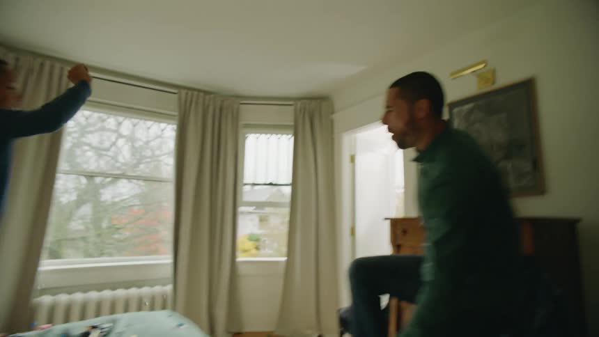 Two children made a mess with toys and are jumping on the bed as their parents enter