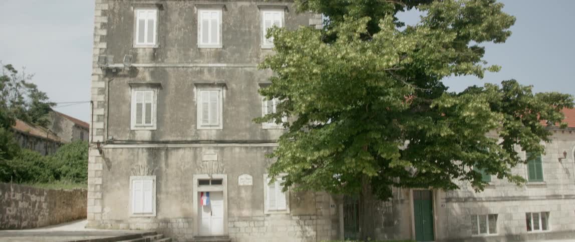 A stone building behind a tree