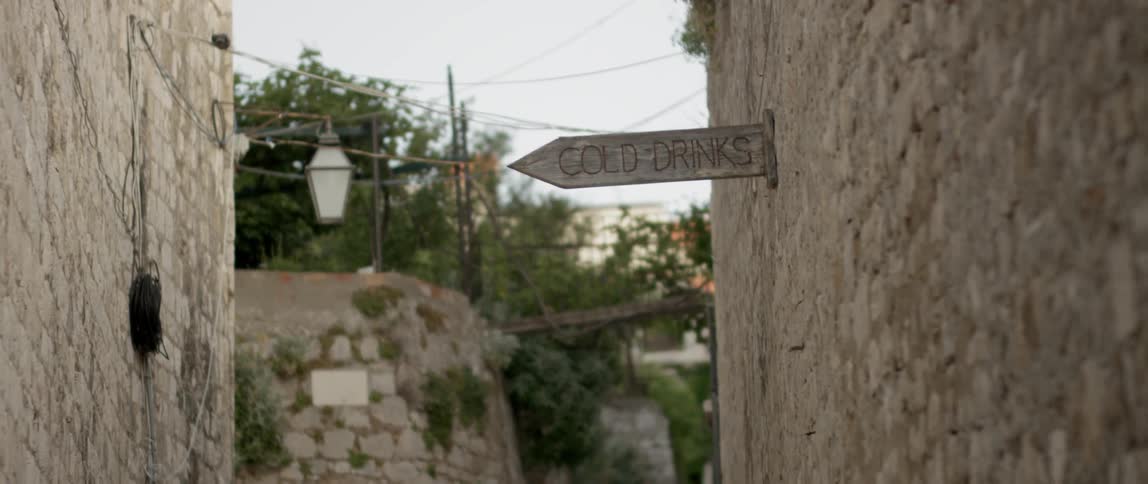 A sign reads cold drinks on the side of a building