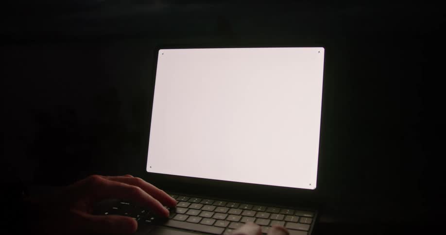Persons hands use tablet in dark room at night