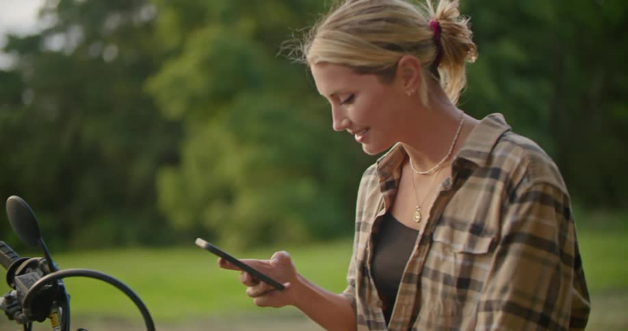 A woman uses her cell phone as a man walks away