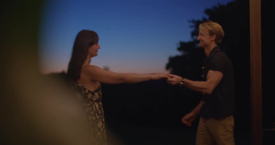 A boyfriend and girlfriend dancing outdoors