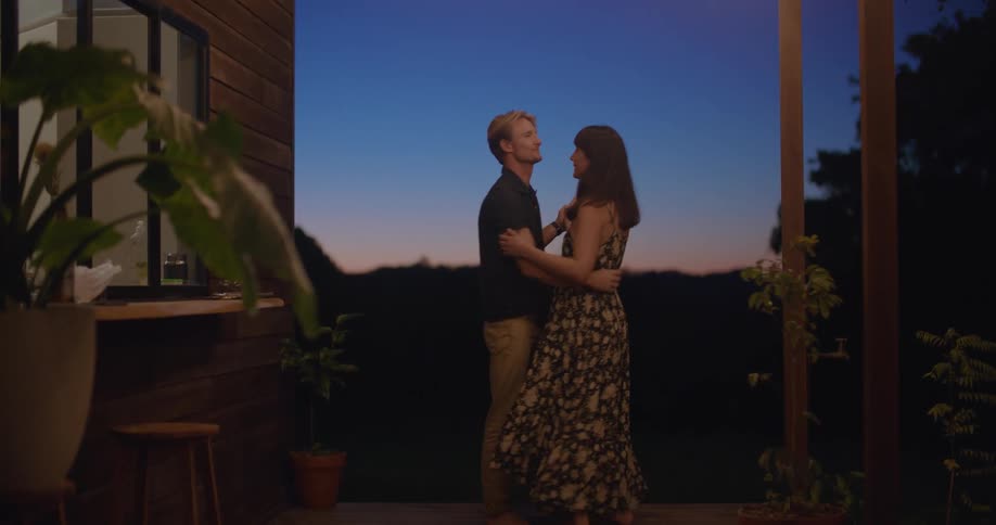 A couple dance on the porch at sunset