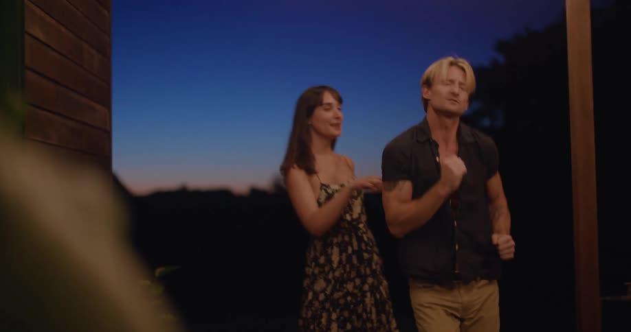 Young happy couple casually dancing on the porch of a country side home at sunset