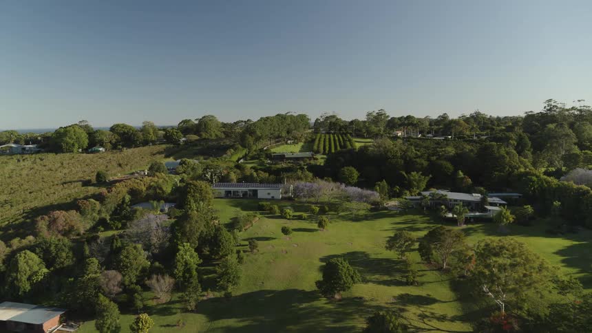 Multiple buildings and homes occupy large green lawns under clear sky