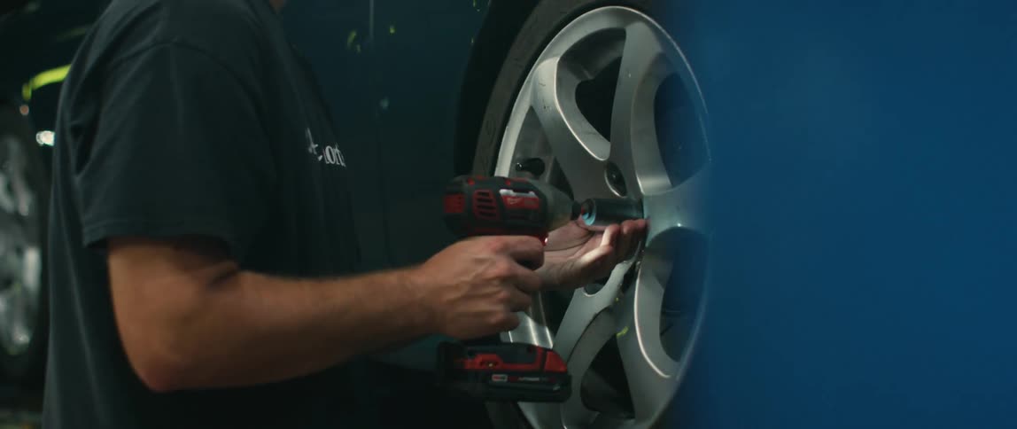 A man removes a tire from the vehicle in the shop