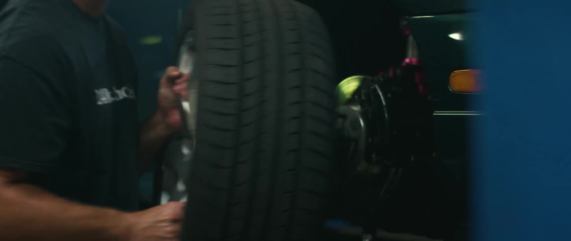 Mechanic removes the tire of a car inside a car shop