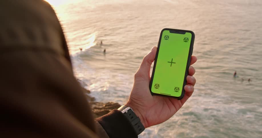 Person holding phone with green screen
