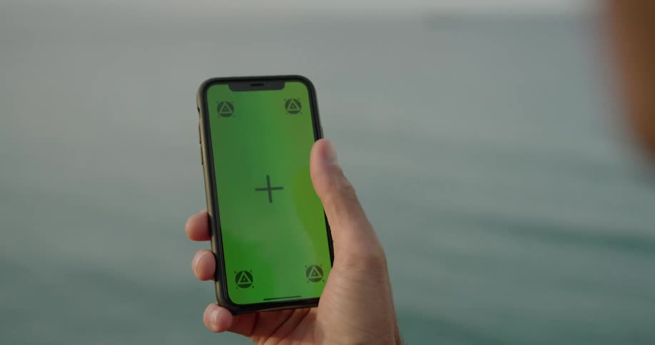 Man swipes up on smartphone screen against the sea