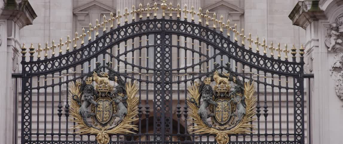 A large iron gate leads to a stone building