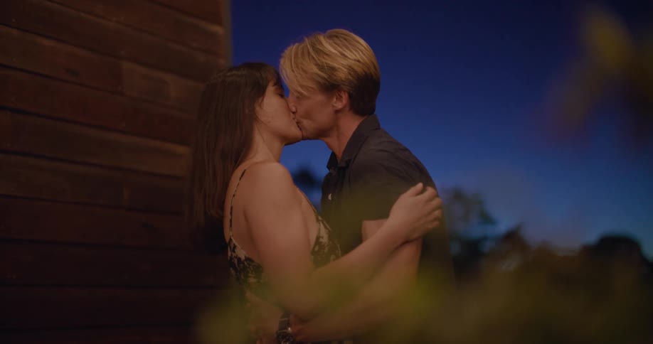 Couple dancing near house at night kisses and hugs