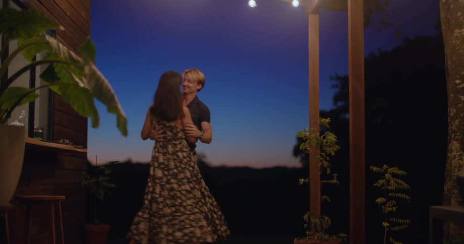 Couple dances on porch at night