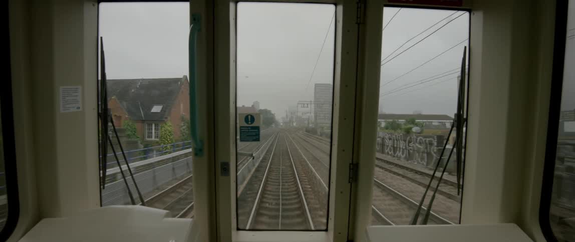 View from the back window of a commuter train as it travels along the tracks