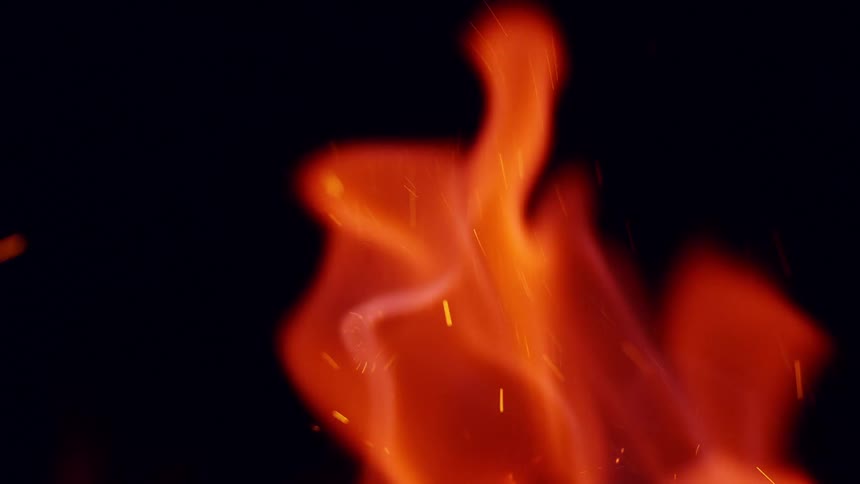 Sparks and embers fly up from glowing orange flames