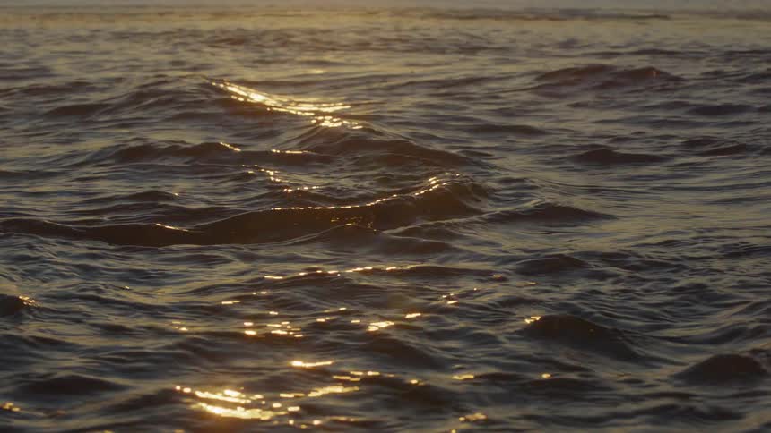 The sun is reflecting on the ocean water as it ripples