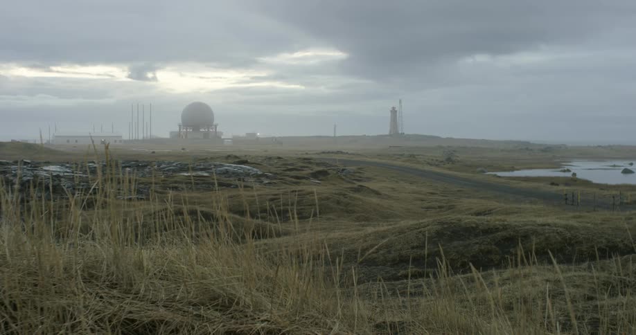 A hilly valley leads to a dome in the distance