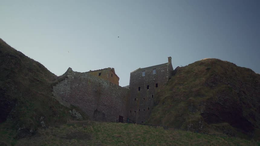 An old castle between two hills in the countryside