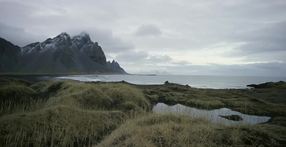 Waves crashing against a shore on a cloudy day