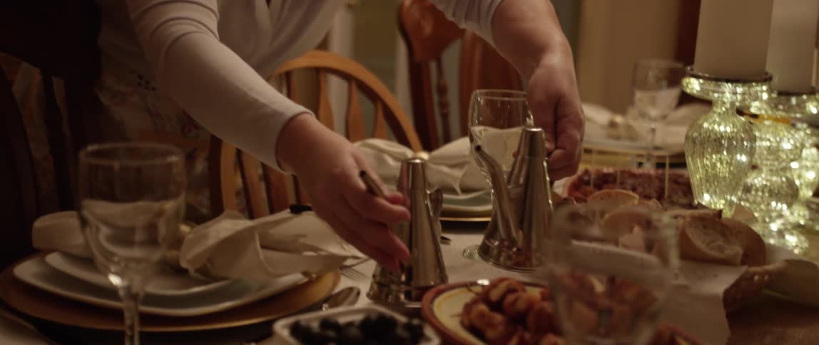 A woman is setting the dining room table