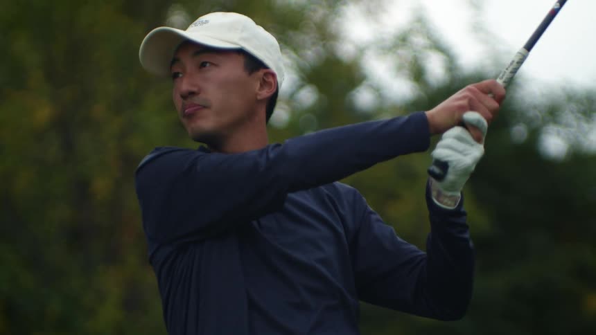 Golfer takes swing then stands looking