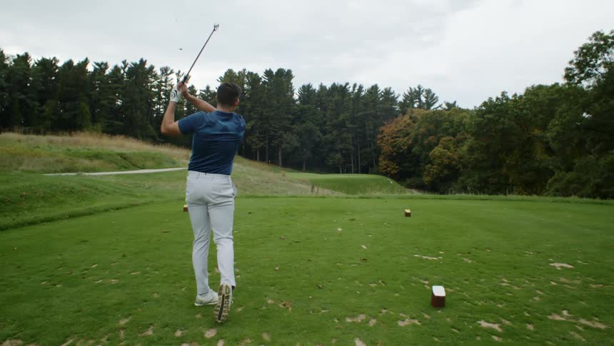 A golfer watches where his ball lands on the course