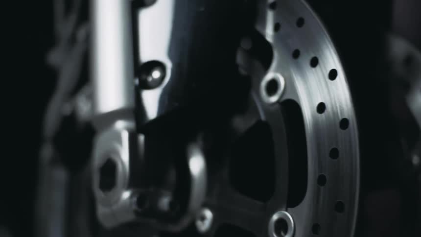Light briefly shines on a wheel in a dark area