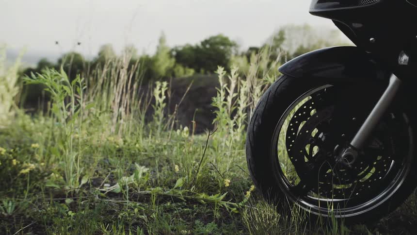 A motorcycle sits on a grassy hill