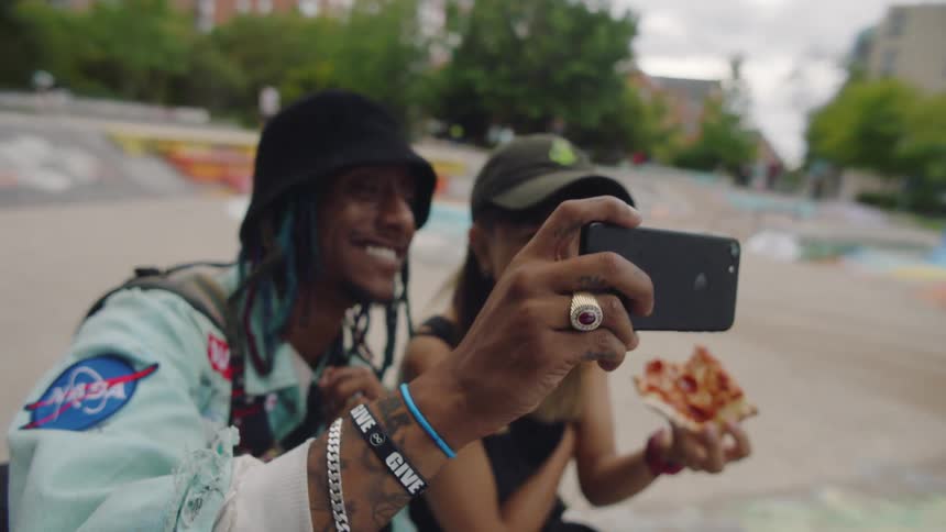 A boyfriend and girlfriend kissing while taking a selfie