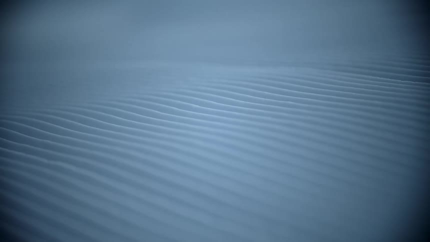 Parallel lines on the surface of soft white sand
