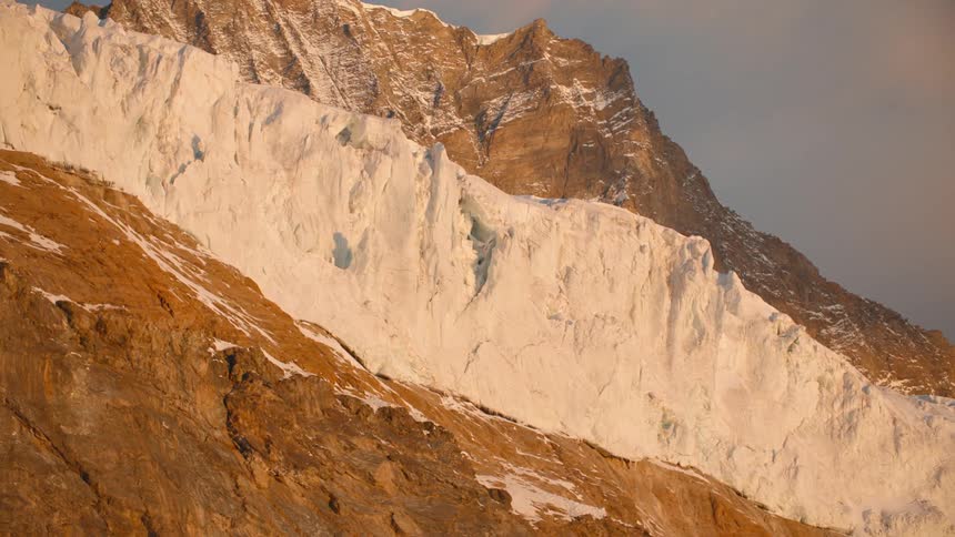 A mountain with patches of ice on a cloudy day