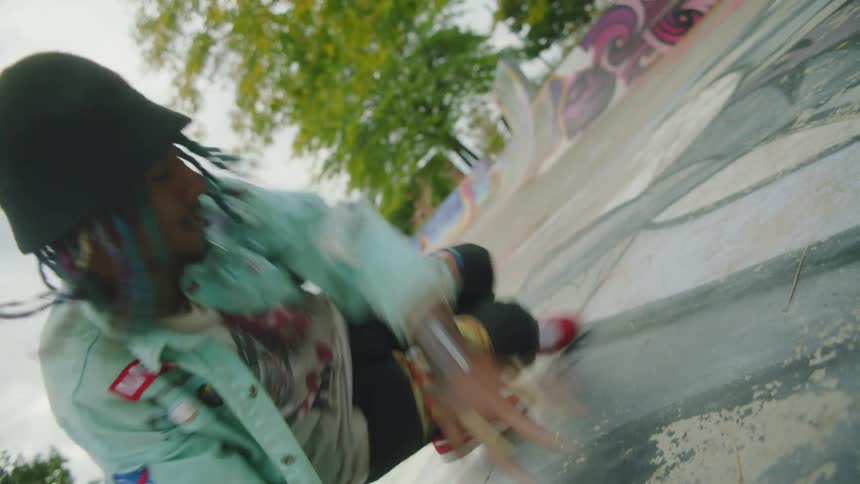 Young man energetically breakdancing in a skate park covered with graffiti