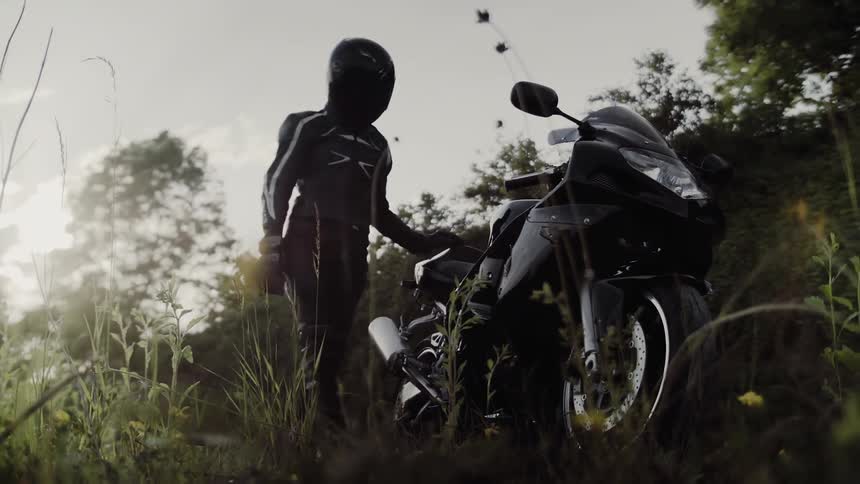 A person gets off their motorcycle