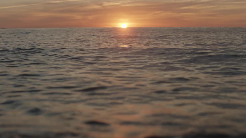 The sun sits low on the horizon as it sets over the ocean