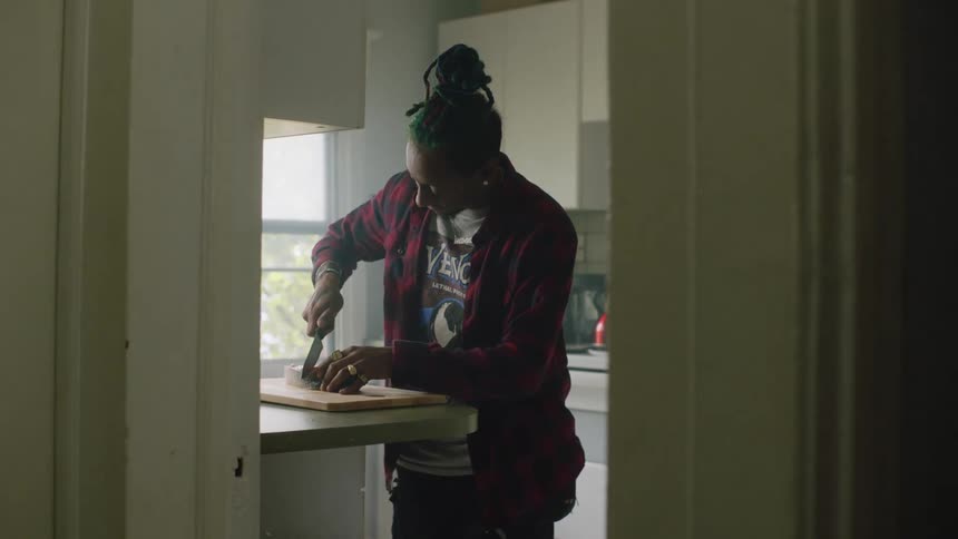 Young man confused on how to cut a piece of fish with a sharp kitchen knife at home