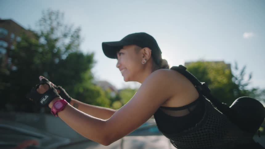 A woman is holding a phone out and taking pictures with a big smile on her face