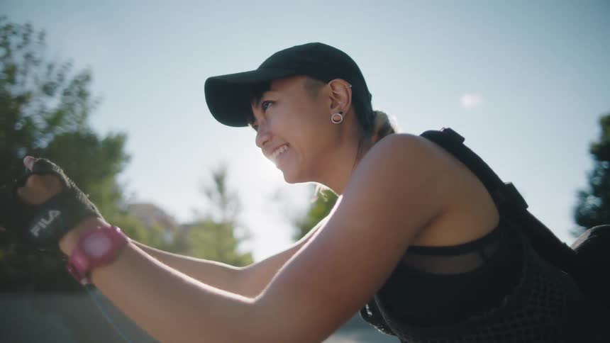 A woman is holding a phone out and taking pictures with a big smile on her face