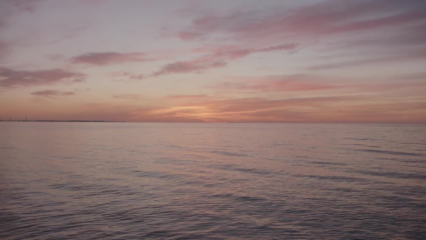 A view of the sun setting at the ocean