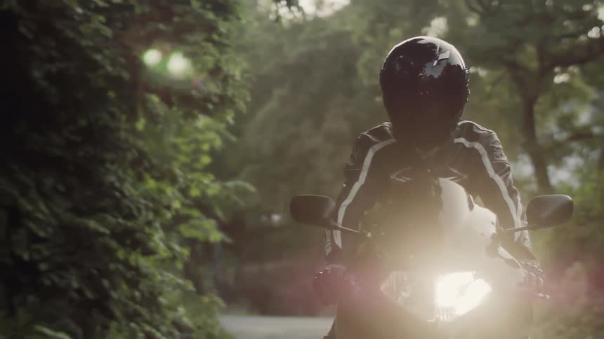 A person rides a black motorcycle