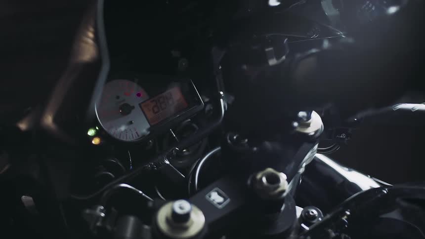 A motorcycle is turned on in a dark area