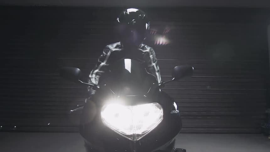 A person starts their motorcycle