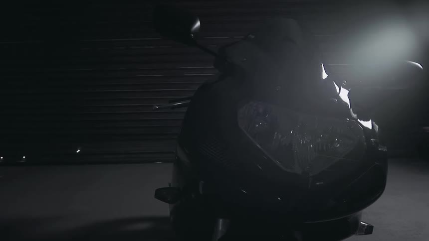 A motorcycle sits in a dark room