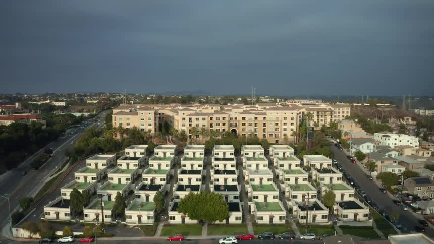 Aerial view of buildings and houses as cars travel on the streets