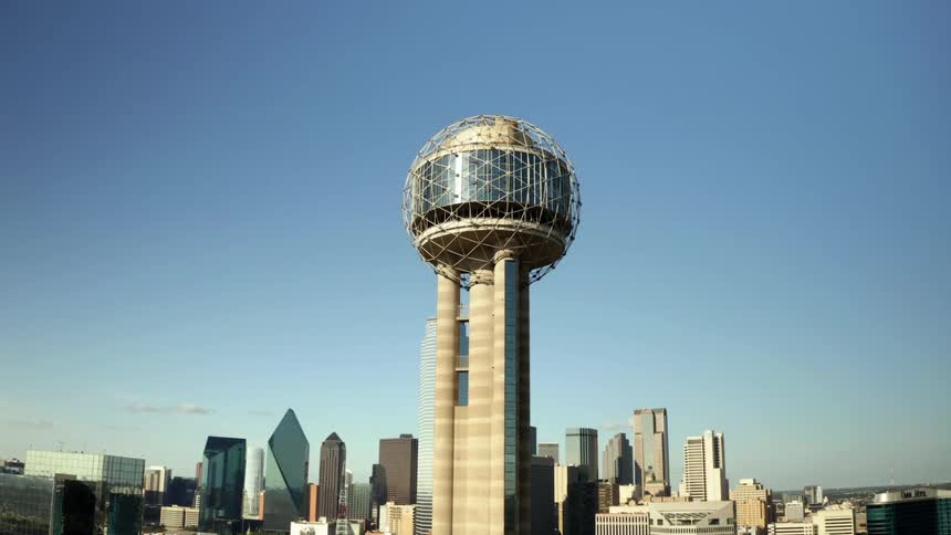 An observation tower covered in a mesh sphere sits near downtown