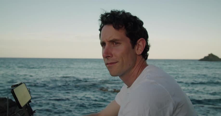 A man is flying a drone by the shore