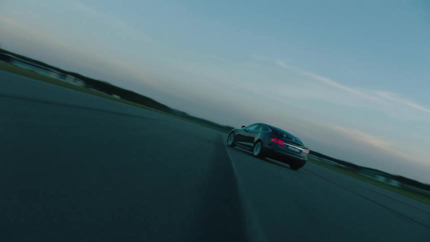 A car races on the road at sunrise