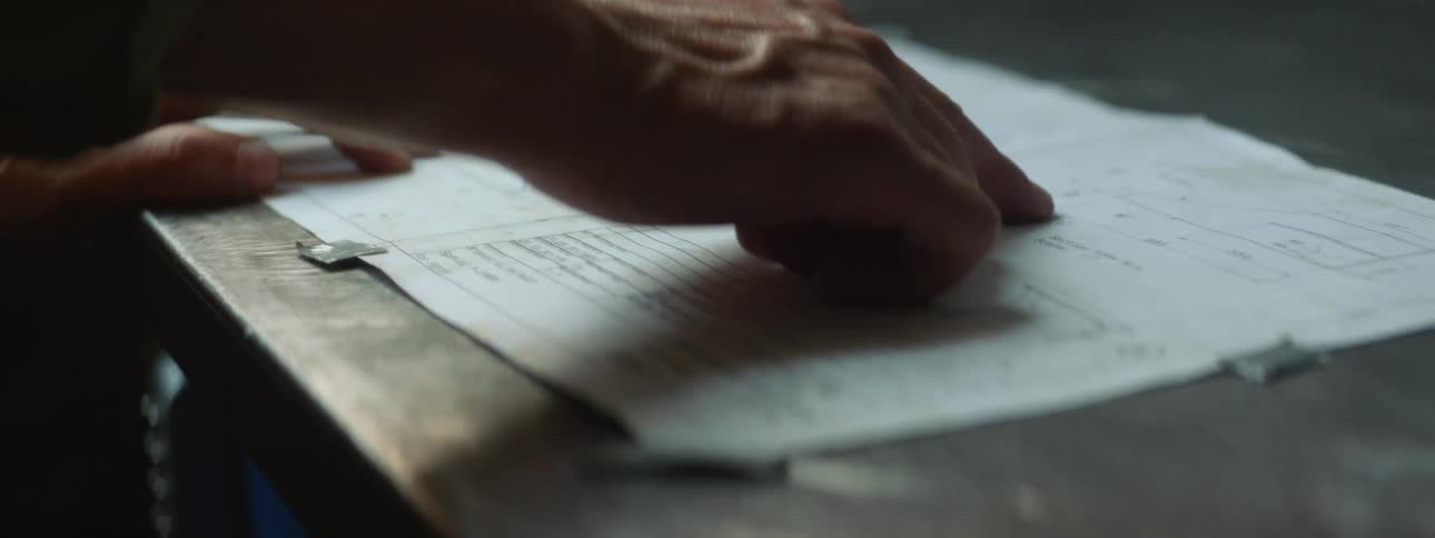 A man sets an instruction manual on a table and spins it around