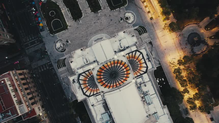 An aerial view looking straight down onto a large church in a city during the day