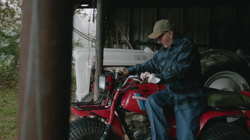 Elderly man working on motorbike